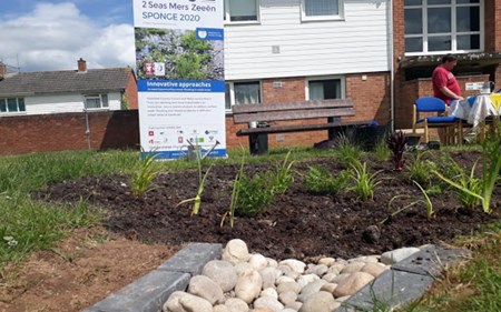 New raingarden and cobbled channel in front of building and information board